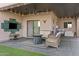 Relaxing covered patio with woven furniture, modern lighting, and an outdoor TV setup at 1049 S Exeter St, Chandler, AZ 85286