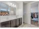 Bathroom features a double sink vanity, large mirror, and access to a walk-in closet at 1189 E Tyler Ln, Casa Grande, AZ 85122