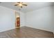 A bright bedroom featuring wood-look floors, ceiling fan and view to bathroom at 1189 E Tyler Ln, Casa Grande, AZ 85122