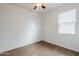 A bright bedroom featuring wood-look floors, ceiling fan, and window providing natural light at 1189 E Tyler Ln, Casa Grande, AZ 85122