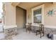 Close-up of a charming front porch with a seating area, desert decor and stone column accents at 1189 E Tyler Ln, Casa Grande, AZ 85122