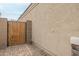 Exterior view of the home's side wall showing a wooden privacy gate with desert landscaping at 1189 E Tyler Ln, Casa Grande, AZ 85122