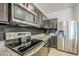 Well-equipped kitchen featuring stainless steel appliances, granite countertops, and dark wood cabinets at 1189 E Tyler Ln, Casa Grande, AZ 85122