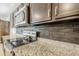 Close-up of the modern kitchen featuring stainless steel appliances, granite countertops, and dark wood cabinets at 1189 E Tyler Ln, Casa Grande, AZ 85122