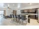 Open kitchen with stainless steel appliances and a large island with bar seating. Living area in background at 1189 E Tyler Ln, Casa Grande, AZ 85122