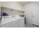 Bright laundry room with white washer and dryer, complemented by built-in shelving for ample storage at 1189 E Tyler Ln, Casa Grande, AZ 85122