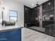 Bathroom featuring black marble tile, a window view, a sleek vanity and shower at 14902 W Oberlin Way, Surprise, AZ 85387