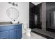 Modern bathroom with a vessel sink, a blue vanity with gold accents, and a black-tiled shower at 14902 W Oberlin Way, Surprise, AZ 85387