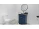 Modern bathroom with blue vanity, round mirror, vessel sink and tile floors at 14902 W Oberlin Way, Surprise, AZ 85387