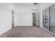 Bright bedroom with carpet, sliding glass doors, and an open doorway at 14902 W Oberlin Way, Surprise, AZ 85387