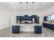 Spacious kitchen with custom blue cabinets, a large center island, and modern pendant lighting at 14902 W Oberlin Way, Surprise, AZ 85387