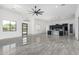 Bright, open-concept living area with sleek tile floors and modern lighting fixtures throughout the space at 14902 W Oberlin Way, Surprise, AZ 85387