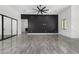 Stylish living area with a black accent wall, modern lighting, and tile flooring for a clean, contemporary look at 14902 W Oberlin Way, Surprise, AZ 85387