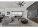 Modern living room features a gray sectional sofa and a large window offering scenic outdoor views at 14902 W Oberlin Way, Surprise, AZ 85387