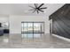 Spacious living room features tile floors, a modern ceiling fan and a sliding glass door with desert views at 14902 W Oberlin Way, Surprise, AZ 85387