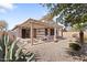 Inviting backyard featuring desert landscaping, a covered patio with built-in benches, and mature trees at 1559 E Peregrine Trl, Casa Grande, AZ 85122