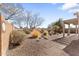 Low maintenance backyard with desert landscaping, gravel, mature trees, and a covered patio at 1559 E Peregrine Trl, Casa Grande, AZ 85122