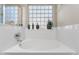 Close up of a soaking tub featuring a decorative glass block window with decor at 1559 E Peregrine Trl, Casa Grande, AZ 85122