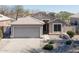 Charming single-story home with a well-manicured front yard and two-car garage at 1559 E Peregrine Trl, Casa Grande, AZ 85122