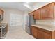 Kitchen with stainless fridge, wood cabinets, quartz countertops, and tile flooring at 1559 E Peregrine Trl, Casa Grande, AZ 85122