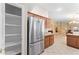 Bright kitchen features stainless steel refrigerator, pantry, and warm wood cabinetry at 1559 E Peregrine Trl, Casa Grande, AZ 85122
