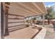 Relaxing covered patio with brick flooring and built-in benches, perfect for outdoor entertaining at 1559 E Peregrine Trl, Casa Grande, AZ 85122