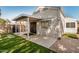 Cozy backyard area featuring a covered patio, artificial grass, and concrete stepping stones at 17406 N 28Th Dr, Phoenix, AZ 85053