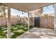 Backyard featuring faux grass, stone pavers, high walls, and a covered patio at 17406 N 28Th Dr, Phoenix, AZ 85053