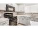Close-up of kitchen featuring quartz countertops, stainless steel appliances, and white cabinets at 17406 N 28Th Dr, Phoenix, AZ 85053