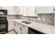 Close-up of kitchen counter with tile backsplash, stainless steel sink and faucet, and white cabinets at 17406 N 28Th Dr, Phoenix, AZ 85053