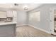 Bright kitchen and dining area with white cabinets, subway tile backsplash, and wood-look tile flooring at 17406 N 28Th Dr, Phoenix, AZ 85053
