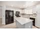 Bright kitchen with white cabinets, tile backsplash, grey kitchen island, and stainless steel appliances at 17406 N 28Th Dr, Phoenix, AZ 85053