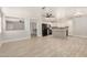 Open-concept living room and kitchen with wood-look tile flooring and modern finishes at 17406 N 28Th Dr, Phoenix, AZ 85053