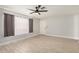 Bright living room with wood-look tile flooring, a ceiling fan, and large windows providing natural light at 17406 N 28Th Dr, Phoenix, AZ 85053