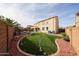 The backyard showcases artificial grass, a pool, and a charming two-story house in a private, landscaped setting at 17687 W Surrey Dr, Surprise, AZ 85388