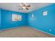 A cozy bedroom painted blue with natural light and a ceiling fan at 17687 W Surrey Dr, Surprise, AZ 85388