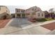 Charming two-story home featuring a spacious driveway, three-car garage, and low-maintenance landscaping with decorative rocks and turf at 17687 W Surrey Dr, Surprise, AZ 85388