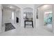 Bright foyer with marble floors, arched doorways, and a charming display shelf for trophies and decorative items at 17687 W Surrey Dr, Surprise, AZ 85388