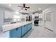 Bright, modern kitchen featuring white cabinets, stainless steel appliances, a stylish blue island, and marble floors at 17687 W Surrey Dr, Surprise, AZ 85388
