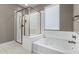 Bright bathroom showcasing a soaking tub and separate glass-enclosed shower at 1936 W Kinfield Trl, Phoenix, AZ 85085