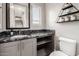 Powder room with gray cabinets, dark countertop, modern mirror and a staircase in the background at 1936 W Kinfield Trl, Phoenix, AZ 85085