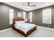 Comfortable bedroom with wood bed frame, soft carpet, and natural light from the windows at 1936 W Kinfield Trl, Phoenix, AZ 85085