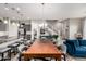 Open floor plan with a wooden dining table, modern gray chairs, kitchen, and staircase at 1936 W Kinfield Trl, Phoenix, AZ 85085