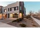 Modern townhome featuring a two-car garage, xeriscaped yard and a neutral colored exterior at 1936 W Kinfield Trl, Phoenix, AZ 85085