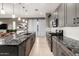 Open kitchen with stainless steel appliances, granite countertops, pendant lights, and white hardwood floors at 1936 W Kinfield Trl, Phoenix, AZ 85085