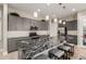 This kitchen features a large granite island, gray cabinets, stainless steel appliances, and wood flooring at 1936 W Kinfield Trl, Phoenix, AZ 85085