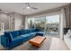 Bright living room with a blue sofa, wooden coffee table, and a large sliding glass door at 1936 W Kinfield Trl, Phoenix, AZ 85085