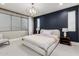 Modern bedroom with a large window, navy blue accent wall, chandelier and hardwood floors at 1936 W Kinfield Trl, Phoenix, AZ 85085