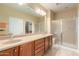 Bathroom features a double sink vanity, a large mirror, and a glass-enclosed shower at 20515 N 271St Ave, Buckeye, AZ 85396