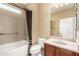 Cozy bathroom with tub and shower, a granite countertop and wood cabinet, and a large framed mirror at 20515 N 271St Ave, Buckeye, AZ 85396